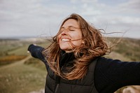 Smiling woman spreading arms, outdoor activity