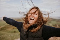 Smiling woman spreading arms, outdoor activity