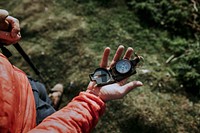 Hiker holding compass on hill photo