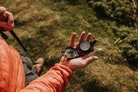 Hiker holding compass on hill photo