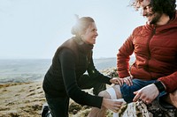 Woman helping man with injured leg photo