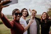 Happy diverse friends taking selfies on smartphone