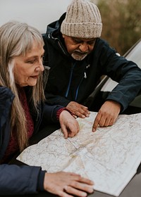 Senior couple looking at map, outdoor travel