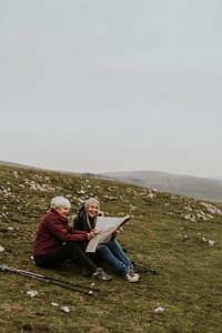 Senior women looking at map, sitting on the hill