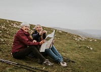 Senior women looking at map, sitting on the hill