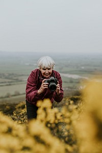 Senior woman taking pictures of flower