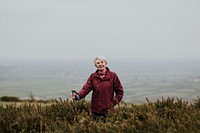 Senior woman trekking through field