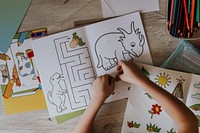 Kid putting sticker on coloring book