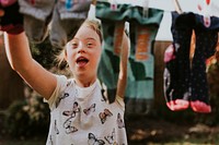 Girl with Down Syndrome hanging laundry, house chore