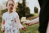 Little girl handing out flower 