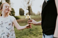 Little girl handing out flower 