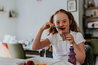 Down syndrome girl eating chocolate pudding