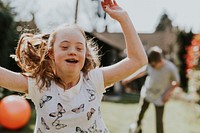 Cheerful girl with Down Syndrome playing in the backyard