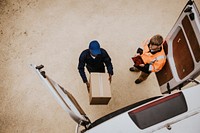 Removal service worker unloading box from the van