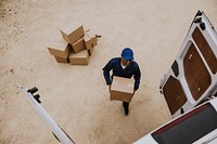 Removal service worker unloading box from the van