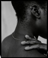 African woman touching shoulder, closeup black & white photo