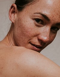 American woman looking over bare shoulder photo