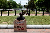                         Abillah Barry Ichingwah poses with a Black Lives Matter sign on Lafayette Square across from the White House at the 2020 Juneteenth Celebration                        