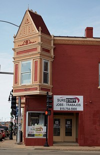                         An elaborately designed corner building, now (as of 2020) housing a job-recruitment center, in DeKalb, Illinois                        