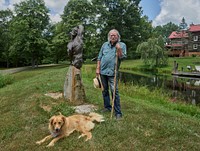                         Celebrated sculptor Sam McKinney (and friend) relax near one of Mr. McKinney's creations in the Rowan County, Kentucky rural settlement of Elliottsville, near Morehead                        