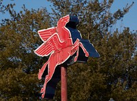                         The classic Mobil Gas Pegasus, or flying horse, sign in the distance beyond a newer Phillips 66 sign, was a mainstay of the old Route 66 Motors, selling used cars and trucks along a surviving section of the old, two-lane U.S. Highway 66 in Rolla, a small city in south-central Missouri                        