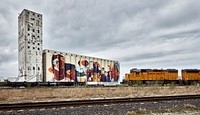                         A freight train approaches the artwork on the northside Wichita, Kansas, Beachner Co. grain elevator holds (as of 2021) the Guinness World Record as the largest mural in the world painted by a single artist, Leo, a female muralist from Colombia                        