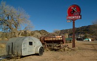                        An old camper stands beneath a Frontier Gasoline station sign at a nostalgic roadside attraction, the Classical Gas Museum, in the Rocky Mountain foothills of northern New Mexico, near the town of Dixon                        