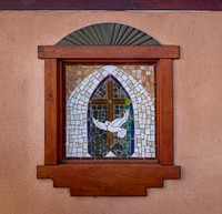                         One of several small stained-glass windows of the El Santuario de Chimayo, a humble but incredibly popular shrine in Chimayo, a New Mexico village on the "High Road," a winding route through the Sangre de Cristo Mountains to and from the capital city of Santa Fe and the art and shopping mecca of Taos                        
