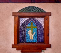                         One of several small stained-glass windows of the El Santuario de Chimayo, a humble but incredibly popular shrine in Chimayo, a New Mexico village on the "High Road," a winding route through the Sangre de Cristo Mountains to and from the capital city of Santa Fe and the art and shopping mecca of Taos                        