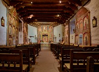                         The sanctuary, filled with hand-painted reredos (altar screens) and other intricate decorations at the El Santuario de Chimayo, a humble chapel in Chimayo, a New Mexico village on the "High Road," a winding route through the Sangre de Cristo mountains to and from the capital city of Santa Fe and the art and shopping mecca of Taos                        