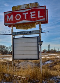                         Time and rust have nearly obscured the name of the motel mentioned on this old sign (it was the Plaza), near Minatare, Nebraska                        