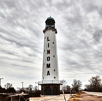                         The Linoma Lighthouse, built in 1924 in Sarpy County, midway from Omaha and Lincoln, Nebraska (its name is a combination of "Lincoln" and "Omaha"), began as a gas station above which the lighthouse-like structure was built as a landmark on U.S. Highway 6 (principal east-west road before the days of high-speed interstate highways), designed to attract visitors to a small lake and beach beneath it                        