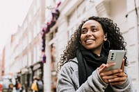 Woman holding mobile phone, walking in the city