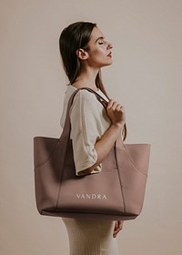 Woman holding brown leather bag, studio shoot
