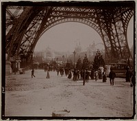 Exposition Universelle de 1900 : personnages sous La tour Eiffel, et perspective du Champ-de-Mars, Paris (VIIème arr.). 1900. Photographie anonyme.