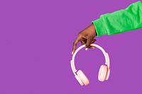 African American woman holding wireless pink headphones