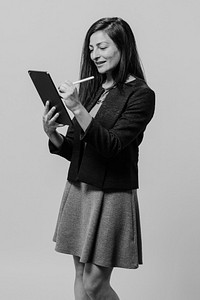 Businesswoman using tablet, greyscale business photo