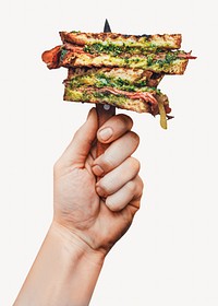 Pesto sandwich held with knife 