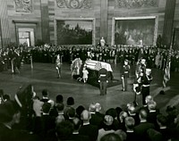 John F. Kennedy Lying in State November 24, 1963Mrs. Kennedy and daughter, Caroline Kennedy, kneel at the catafalque with President Kennedy casket. Photo by Architect of the Capitol photographers. Original public domain image from Flickr