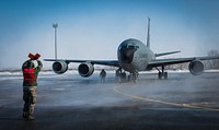 A U.S. Air Force crew chief with the 376th Expeditionary Aircraft Maintenance Squadron guides a KC-135 Stratotanker aircraft after the last combat refueling mission over Afghanistan at the Transit Center at Manas, Kyrgyzstan, Feb. 24, 2014.