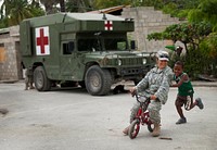 U.S. Army Master Sgt. Elizabeth Limon, with the 486th Civil Affairs Battalion, tries out a boy's bike near the site of a U.S. military-built medical clinic, at Palo Alto, Dominican Republic, June 19, during humanitarian exercise Beyond the Horizon 2014 in Palo Alto, Dominican Republic, June 19, 2014.