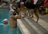 U.S. Air Force swimmer August O'Neill kisses his service dog, Kai, during the 2014 Warrior Games in Colorado Springs, Colo., Sept. 30, 2014.
