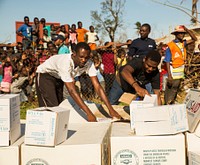 Haitian citizens work to organize donated material during a supply delivery at Dame Marie, Haiti, Oct. 11, 2016.