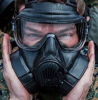 U.S Marine Corps Cpl. Aaron M. Henson, a combat correspondent with the Public Affairs Office, Headquarters and Headquarters Squadron, conducts a functions check on his M50 field protective mask during chemical, biological, radiological and nuclear (CBRN) defense training before entering the gas chamber at Marine Corps Air Station Iwakuni, Japan, Feb. 23, 2017.