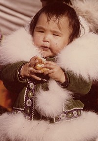 Eskimo youngster attending the Point Hope Whaling Festival and wearing a ruff of arctic fox fur. Original public domain image from Flickr