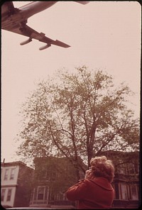 Mary Bruno Holds Her Ears Against Noise of Jet Coming in for a Landing on Runway 15r at Logan Airport. Original public domain image from Flickr