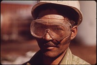 Worker from Mexico Wears Goggles to Protect His Eyes from Dust at a Cedar Mill near Leakey, Texas, and San Antonio 12/1973. Original public domain image from Flickr