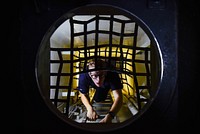 U.S. Navy Machinist’s Mate Fireman Shane Brooks climbs up a ladder leading from a shaft-alley aboard the aircraft carrier USS Theodore Roosevelt (CVN 71) in the Pacific Ocean Nov. 8, 2017.