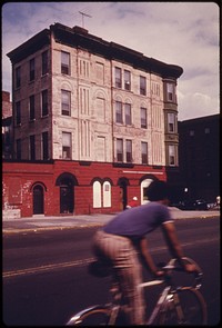 Man riding bicycle on road. Original public domain image from Flickr