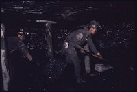 Two Miners Are Cleaning Out Loose Coal by Hand So Canvas Walls Can Be Hung to Control the Air Flow in the Virginia-Pocahontas Coal Company Mine #3 near Richlands, Virginia 04/1974. Photographer: Corn, Jack. Original public domain image from Flickr